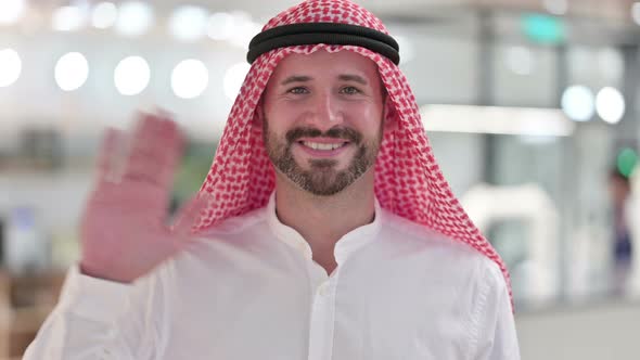 Cheerful Arab Businessman Waving at the Camera 