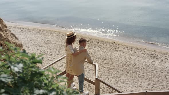 Romantic Pair Hugging Standing Beach Staircase Enjoying Summer Ocean View