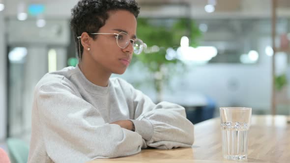 Casual African Woman with Glass of Water Getting Worried 