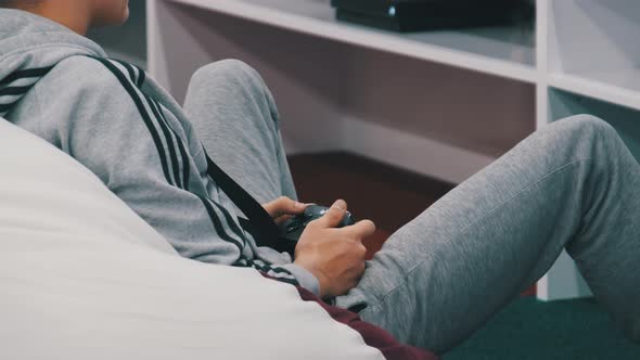 Teenager Plays a Game Console with Joystick in a Children's Entertainment Center