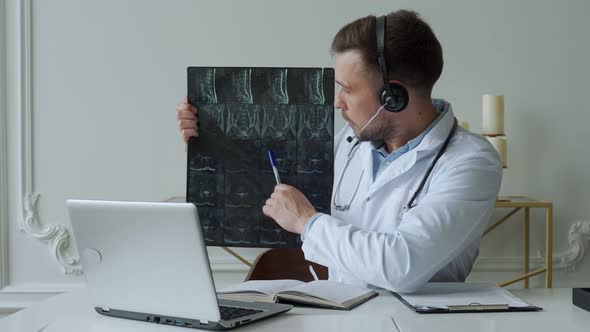 Male Doctor Listening to Patient During Telemedicine Session