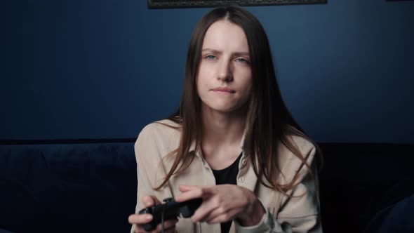 Woman Playing a Video Game at Home at Night, Excited Gamer Woman Sitting on a Couch, Playing Video