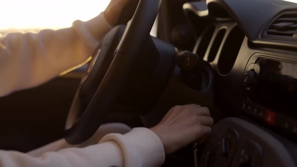 Blonde Woman Startting Car on the Coast During Golden Hour