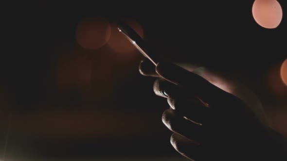 Young Woman's Hands Using Her Smart Phone At Night