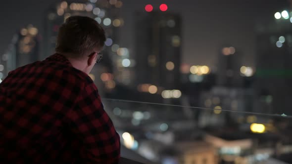 Young Handsome Hipster Man Looking At View Of The City At Night