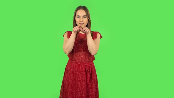 Tender Girl in Red Dress Is Smiling and Showing Heart with Fingers Then Blowing Kiss. Green Screen