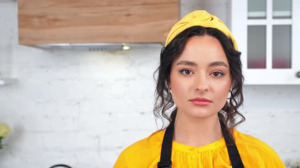 Close Up Serious Housewife Turns Head Looking Camera in Home Modern Kitchen