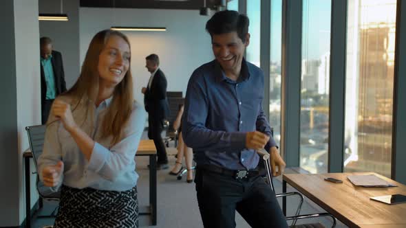 Attractive Confident Colleagues Celebrating with Dance in Their Office.