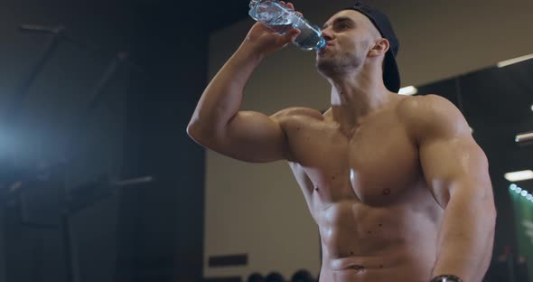 Handsome Shirtless Athletic Sports Men Resting After Intensive Workout and Drinking Water