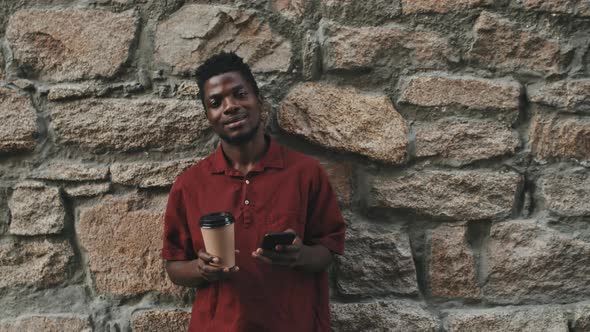 Portrait of Black Man with Takeaway Coffee and Smartphone