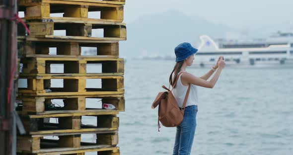 Woman take photo on cellphone in city