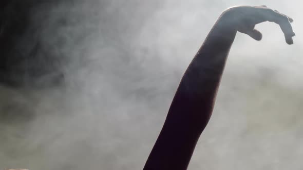 Young Dancer Making Hand Movement in Smoky Studio