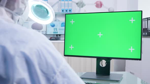 Static Shot of Research Staff in White Coverall Looking at Isolated Mock-up Monitor