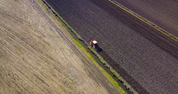 Modern Tractor Plows Boundless Dark Brown Unseeded Field