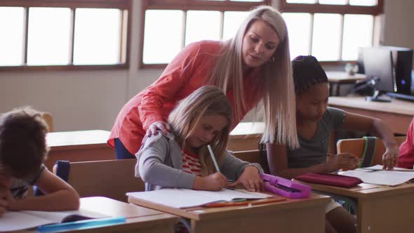 Female teacher talking to a girl in the class at school