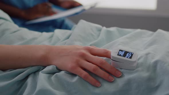 Close Up of Hospitalized Woman with Finger Heart Rate Monitor Showing Pulse