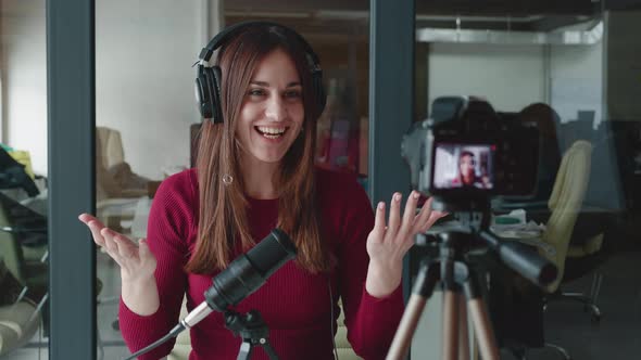 Young Female in Headphones Rodecaster Making Audio Podcast on Office Studio Background