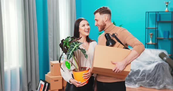 Portrait of Smiling Couple Standing at New Home Carrying Boxes