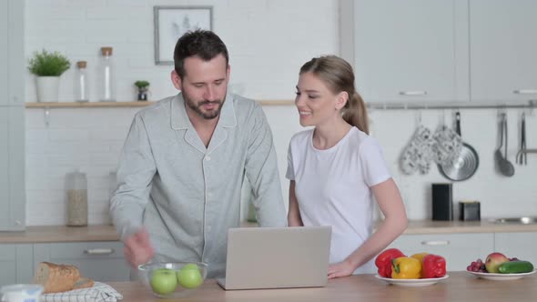 Woman and Man Doing Video Call on Laptop in Kitchen