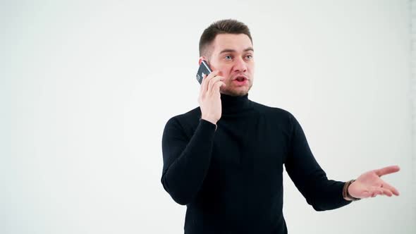 Portrait of handsome man talking the phone indoors