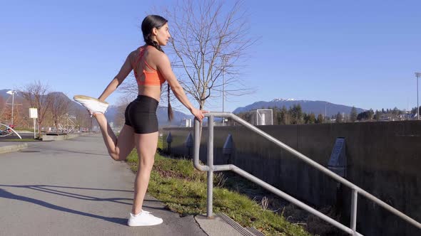 Athletic young woman stretching legs before morning Winter run