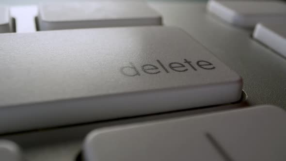 Close up of finger pressing the Delete key on computer keyboard