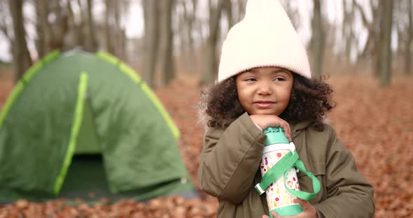 Mixed Race Girl Staying Near Camp in Autumn Forest