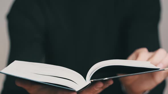 Young Man Reading a Book and Turning Pages Close Up Slow Motion