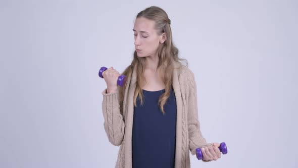 Young Pregnant Woman Exercising with Dumbbells