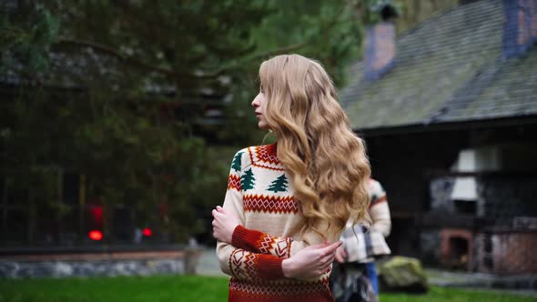 Young handsome man covers beautiful girl with blanket outside. 