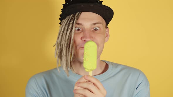 Young Funny Man in Black Cap Licking Ice Cream