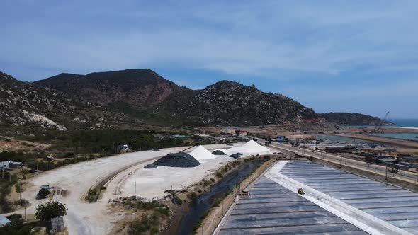 Piles of harvested salt stacked beside industrial salt field in Phan Rang, Vietnam