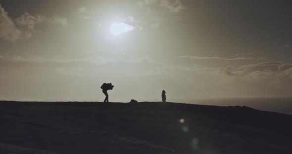 Man takes photo of person on hilltop