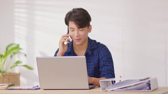 Entrepreneur handsome business asian man wear casual blue shirt working with laptop