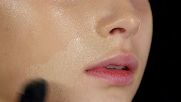 Makeup Artist Applies Concealer on the Model's Face. Black. Closeup