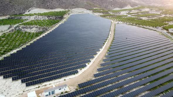 Solar panels farm aerial view from drone shot while sun setting. Small photovoltaic cell panels