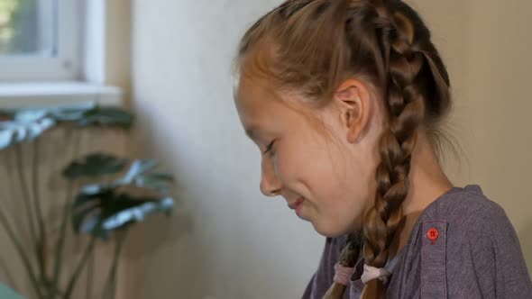 Red Haired Girl with Freckles Smiling and Drawing at School