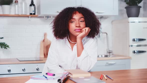 Young Successful African American Woman Freelancer Sits at Table Looks at your