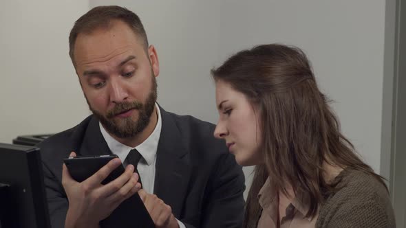 Male office worker works with female office worker discussing a project