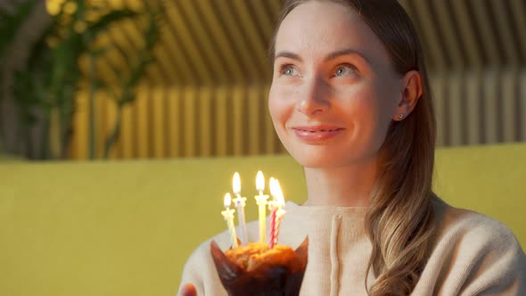 Woman Makes a Wish Blows Out the Candles on a Birthday Cake and Laughs