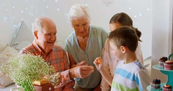 Caucasian grandfather giving chocolate to grandson in a comfortable home 4k