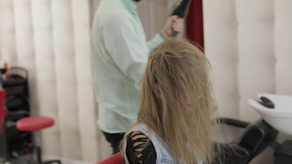 Professional Hairdresser Styling Blows Lacquer on Model Hair with a Hair Dryer