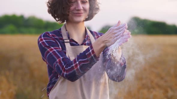 Girl Baker Or Miller Claps Her Hands, Smiles. Woman Checks Flour From New Crop. Concept Of Organic