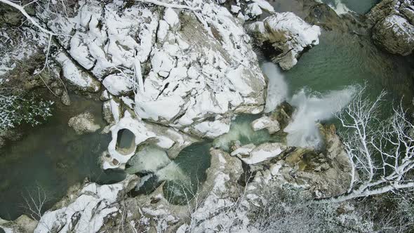 Waterfall Flowing From White Rocks Into a Lake in the Forest