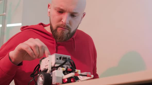 Close Up of a Robotics Teacher Hands Online Course for His Students Using a Robot