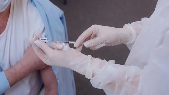 Medic Dials the Vaccine Into a Syringe and Gives the Injection to the Patient