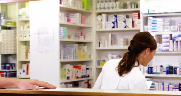 Customer giving prescriptions of medicine to pharmacist