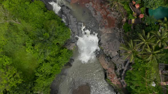 Top Down Overhead Aerial View of a Jungle River with Waterfall and Colorful Outdoor Restaurant in a