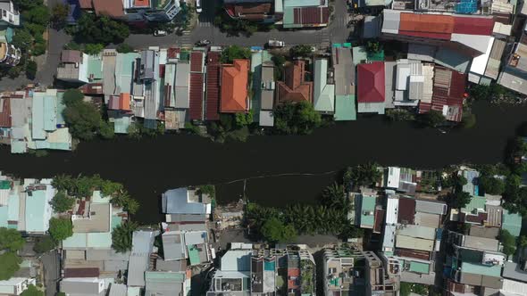 Aerial top down tracking shot over high density suburban area with small canal. Shot on a sunny day