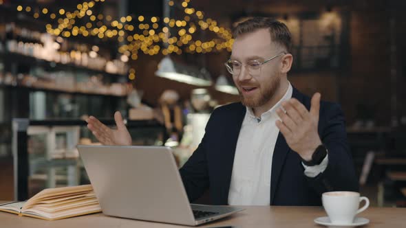 Businessman Talking on Video Call at Cafe